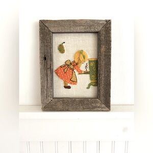 Vintage crewel embroidered girl baking.